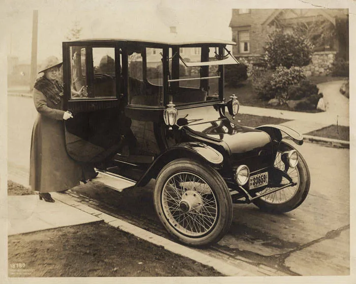 Photographie d'archive : une conductrice près d'une voiture électrique, 1918
